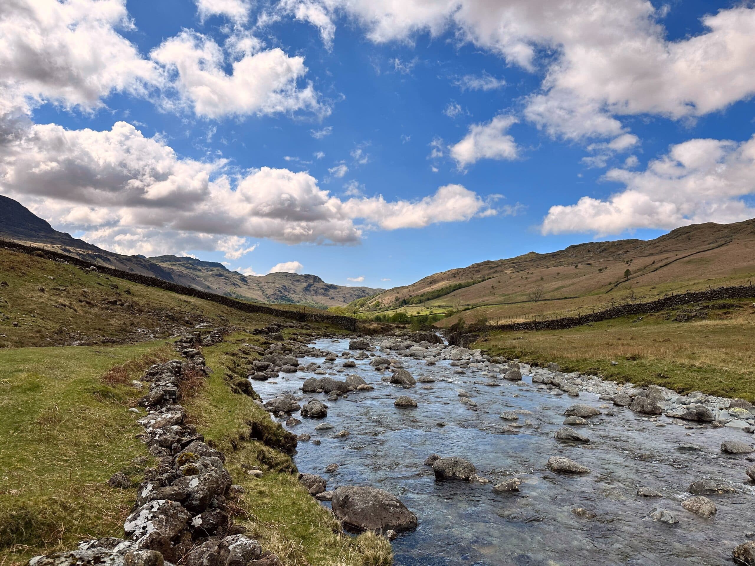 Cumbrian fells and a clear river under blue sky